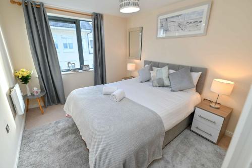 een slaapkamer met een groot bed en een raam bij One Bedroom Apartment TCA-78 in Watford