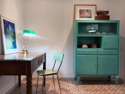 a desk and a chair next to a green cabinet at AFFITTACAMERE SobborgoSpina47 in Sarzana