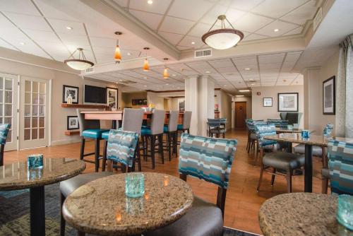 a restaurant with tables and chairs and a bar at Hampton Inn Joplin in Joplin