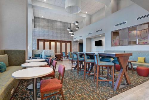 a restaurant with tables and chairs and a bar at Hampton Inn & Suites Middleburg, Fl in Middleburg