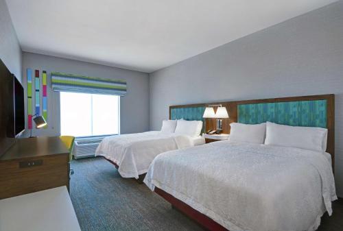 a hotel room with two beds and a television at Hampton Inn & Suites Middleburg, Fl in Middleburg