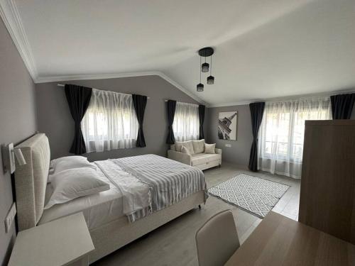 ein Schlafzimmer mit einem Bett, einem Stuhl und einem Tisch in der Unterkunft Luxurious Villa in the Heart of Göcek in Fethiye