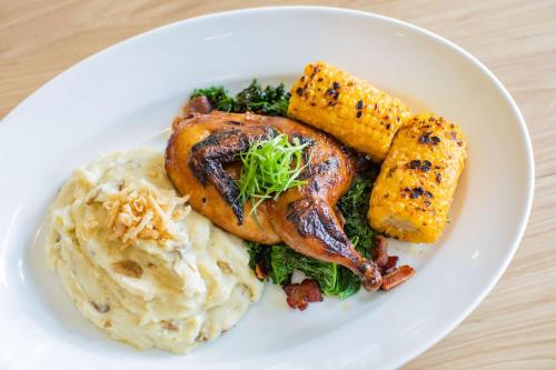 a plate of food with chicken and mashed potatoes and vegetables at Embassy Suites By Hilton Oahu Kapolei - FREE Breakfast in Kapolei