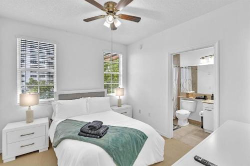 a white bedroom with a bed and a ceiling fan at Gorgeous Townhouse Beach Access Resort Amenities in Hallandale Beach