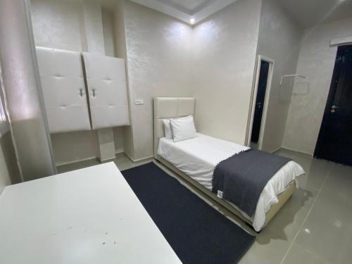 a white room with two beds and white cabinets at GUITAR PALACE - Chambres d'hôtes in Bni Quolla
