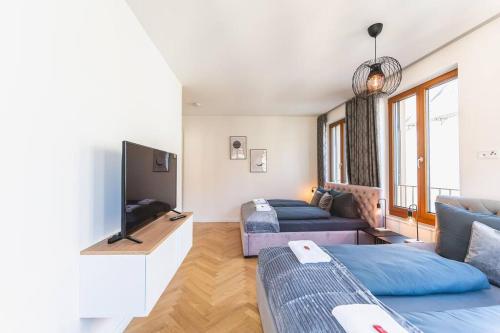 a living room with two beds and a flat screen tv at TIP! Design trifft Lage 120 qm Premium Apartment in Dresden