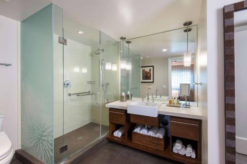 a bathroom with a sink and a glass shower at Hilton Grand Vacations Club Kings Land Waikoloa in Waikoloa