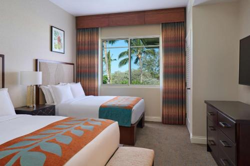 a hotel room with two beds and a window at Hilton Grand Vacations Club Kings Land Waikoloa in Waikoloa