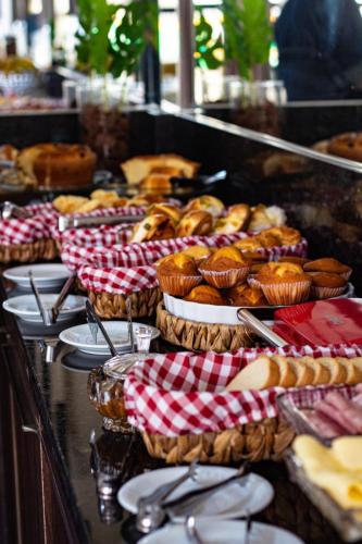 a buffet of pastries and donuts in baskets on a table at Hotel Maxsuel in Cachoeirinha