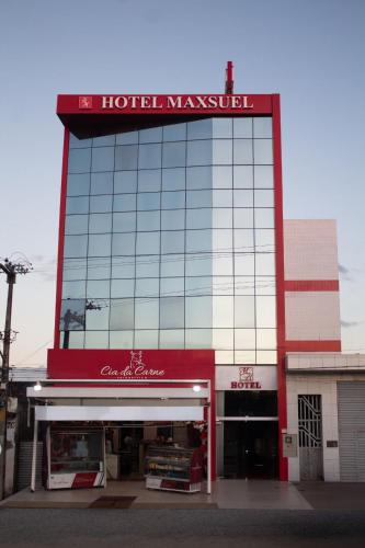 a building with a sign on top of it at Hotel Maxsuel in Cachoeirinha