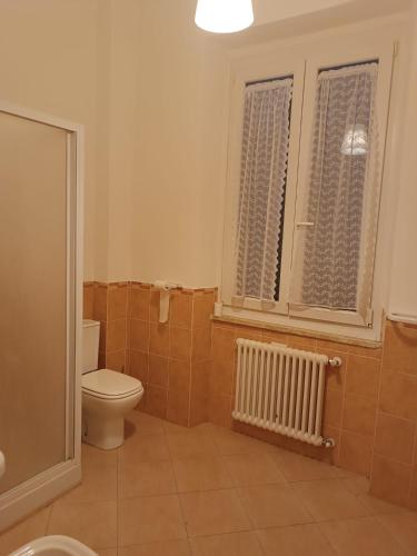 uma casa de banho com um WC e uma janela em La Casa sull'argine 2 em Sarzana