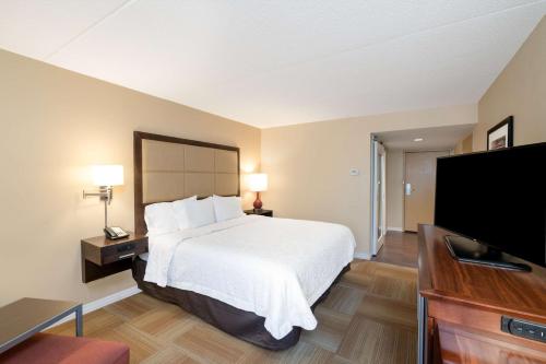 a hotel room with a bed and a flat screen tv at Hampton Inn Lafayette in Lafayette