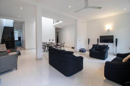 a living room with couches and a dining room at Stylish 4BR+3.5BA home wt AC + Rooftop + Parking in Moratuwa