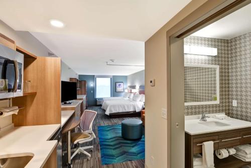 ein Hotelzimmer mit einem Bett und einem Bad in der Unterkunft Home2 Suites By Hilton Lafayette in Lafayette