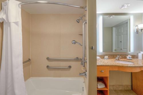 a bathroom with a shower and a tub and a sink at Homewood Suites Lafayette in Lafayette