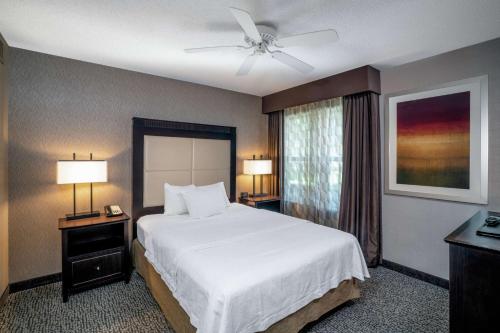 una camera con letto bianco e ventilatore a soffitto di Homewood Suites Lafayette a Lafayette