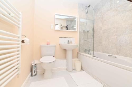 a bathroom with a toilet and a sink and a bath tub at One Bedroom Apartment TCA-78 in Watford