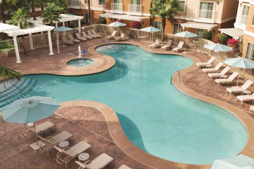 una vista aérea de una piscina con sillas y sombrillas en Homewood Suites by Hilton La Quinta, en La Quinta