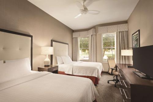 ラキンタにあるホームウッド スイーツ バイ ヒルトン ラ キンタのベッド2台、薄型テレビが備わるホテルルームです。