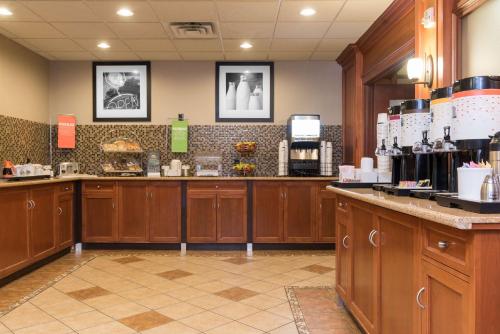 a coffee shop with wooden cabinets and a counter at Hampton Inn & Suites East Lansing in Okemos