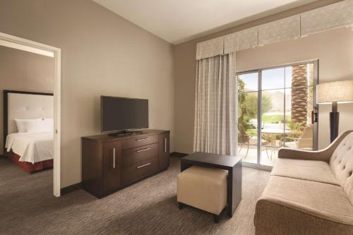 a hotel room with a bed and a television at Homewood Suites by Hilton La Quinta in La Quinta