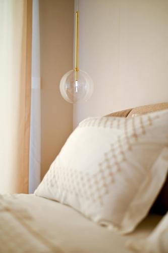 a bed with a white pillow and a lamp at Villa Rosemary East in Makarska