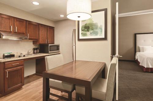 a kitchen and dining room with a table and a bed at Homewood Suites by Hilton La Quinta in La Quinta