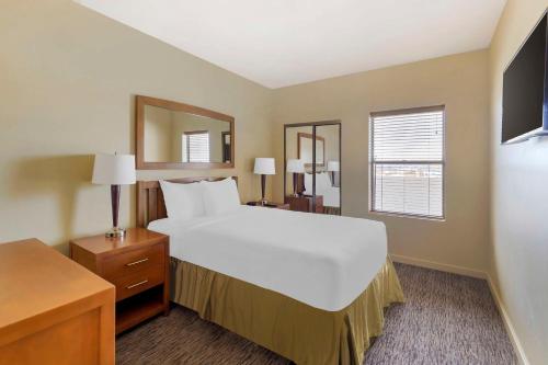 ein Schlafzimmer mit einem großen weißen Bett und einem Spiegel in der Unterkunft Hilton Vacation Club Cancun Resort Las Vegas in Las Vegas