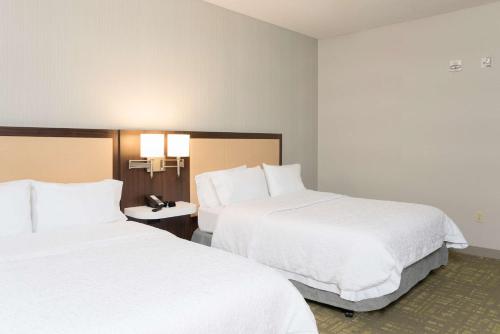 two beds in a hotel room with white sheets at Hampton Inn & Suites East Lansing in Okemos