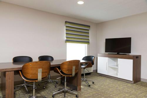 a conference room with a table and chairs and a television at Hampton Inn & Suites East Lansing in Okemos
