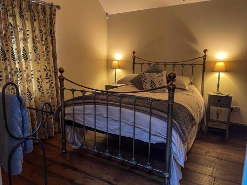 a bedroom with a bed and two lamps and a curtain at The Udderhouse - Udderly Unforgettable Retreat in Donyatt