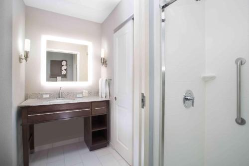 a bathroom with a sink and a shower with a mirror at Homewood Suites By Hilton Las Vegas City Center in Las Vegas