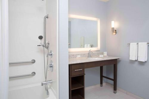 a bathroom with a sink and a shower with a mirror at Homewood Suites By Hilton Las Vegas City Center in Las Vegas