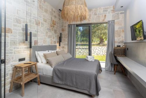 sypialnia z łóżkiem i dużym oknem w obiekcie Villa Ersi w mieście Kateleios