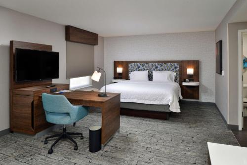 a hotel room with a bed and a desk and a television at Hampton Inn & Suites Las Vegas Airport in Las Vegas