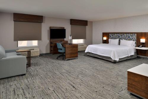 um quarto de hotel com uma cama e uma televisão em Hampton Inn & Suites Las Vegas Airport em Las Vegas