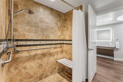 a bathroom with a shower with a bench in it at Hilton Grand Vacations Club Flamingo Las Vegas in Las Vegas