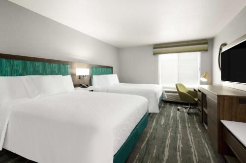 a hotel room with two beds and a flat screen tv at Hampton Inn & Suites Las Vegas-Henderson in Las Vegas