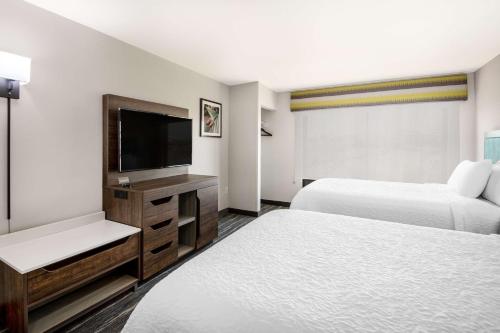 a hotel room with two beds and a flat screen tv at Hampton Inn & Suites Las Vegas-Henderson in Las Vegas