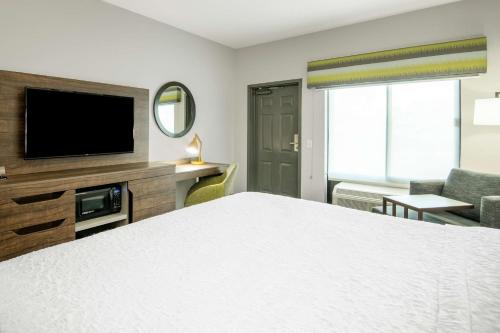 a hotel room with a bed and a flat screen tv at Hampton Inn & Suites Las Vegas-Henderson in Las Vegas