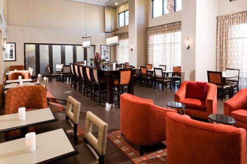 a restaurant with orange chairs and tables and a dining room at Hampton Inn & Suites Las Vegas South in Las Vegas