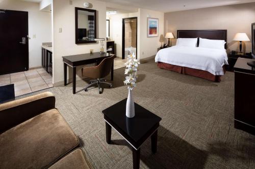 Habitación de hotel con cama y sala de estar. en Hampton Inn & Suites Las Vegas South, en Las Vegas