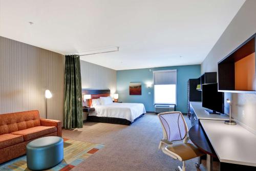 a hotel room with a bed and a couch at Home2 Suites By Hilton Las Vegas Strip South in Las Vegas
