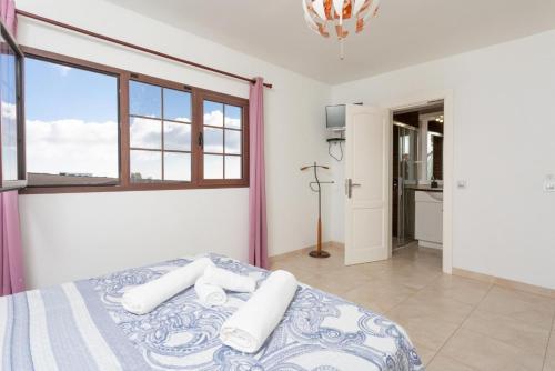 a bedroom with a bed with white towels on it at Villa Santana in Conil