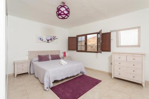 a white bedroom with a bed and a window at Villa Santana in Conil