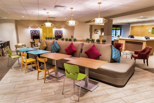 a lobby with a couch and tables and chairs at Home2 Suites by Hilton Las Vegas Stadium District in Las Vegas