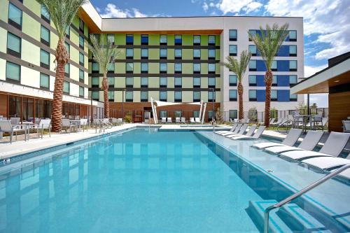 a swimming pool with chairs and a hotel at Home2 Suites by Hilton Las Vegas Convention Center - No Resort Fee in Las Vegas