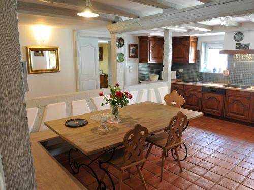 a kitchen with a wooden table and chairs and a kitchen with a counter at Gîte Marcel et Marianne jardin et parking privatifs in Ebersheim