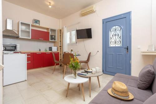 a living room with a blue door and a kitchen at Flora Maisonettes 2 in Gaios