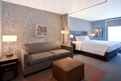 a hotel room with a bed and a couch at Home2 Suites by Hilton Las Vegas Convention Center - No Resort Fee in Las Vegas